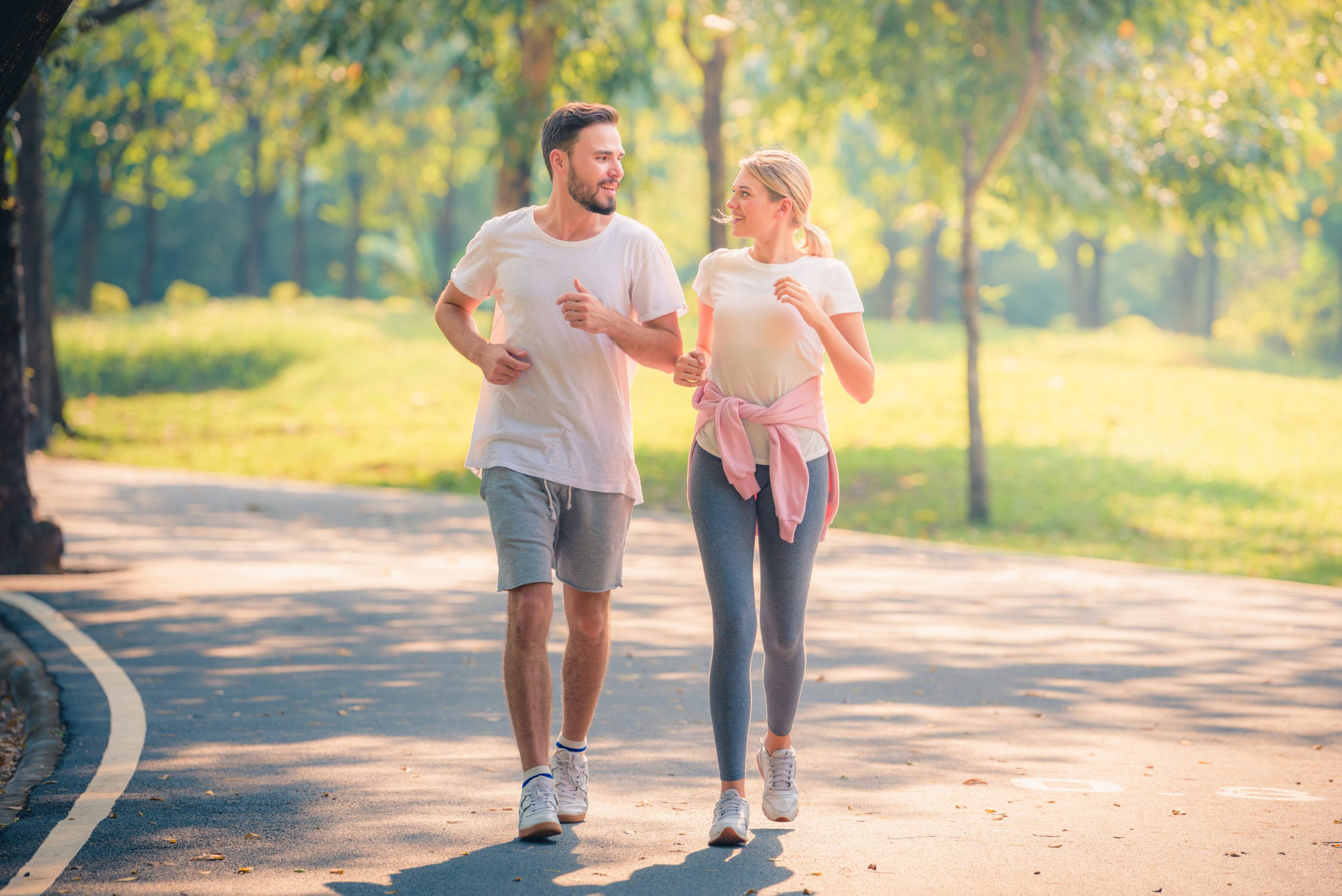 Young couple running through the park after taking CBD pre workout.